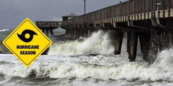 large waves crashing into a wooden pier at the beach