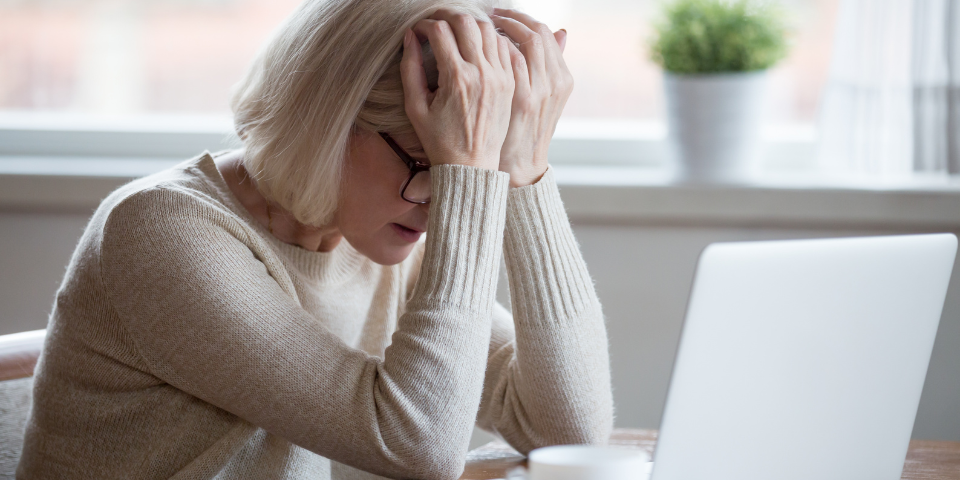 Middle aged woman in front of laptop frustrated 