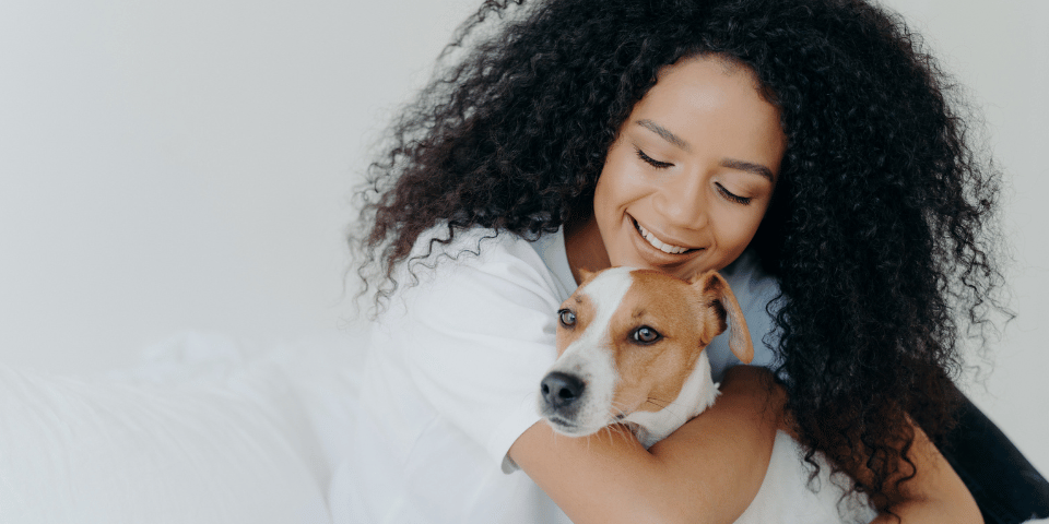 Young woman hugging her small dog