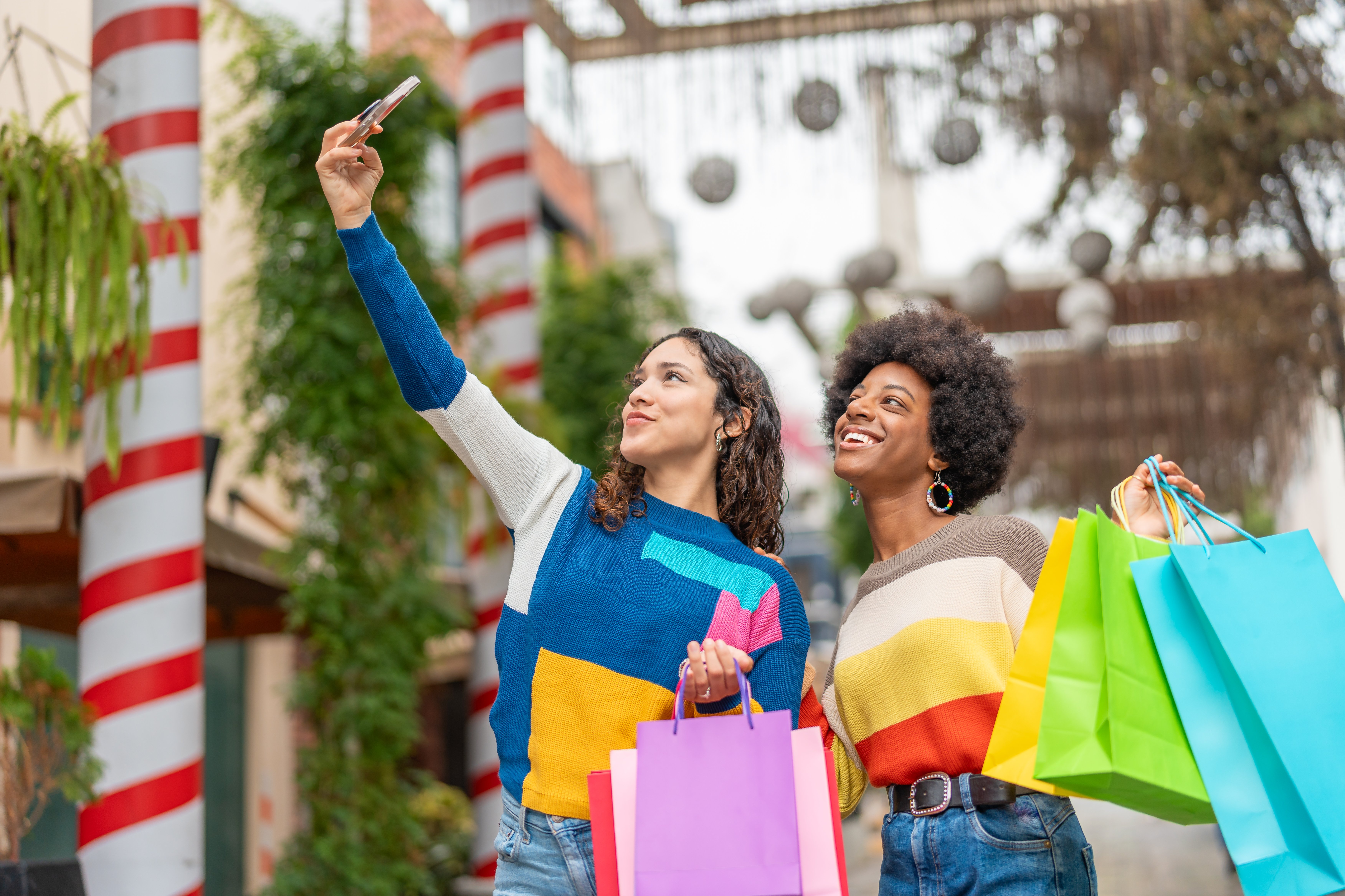 Two girls shopping with colorful clothes and bags